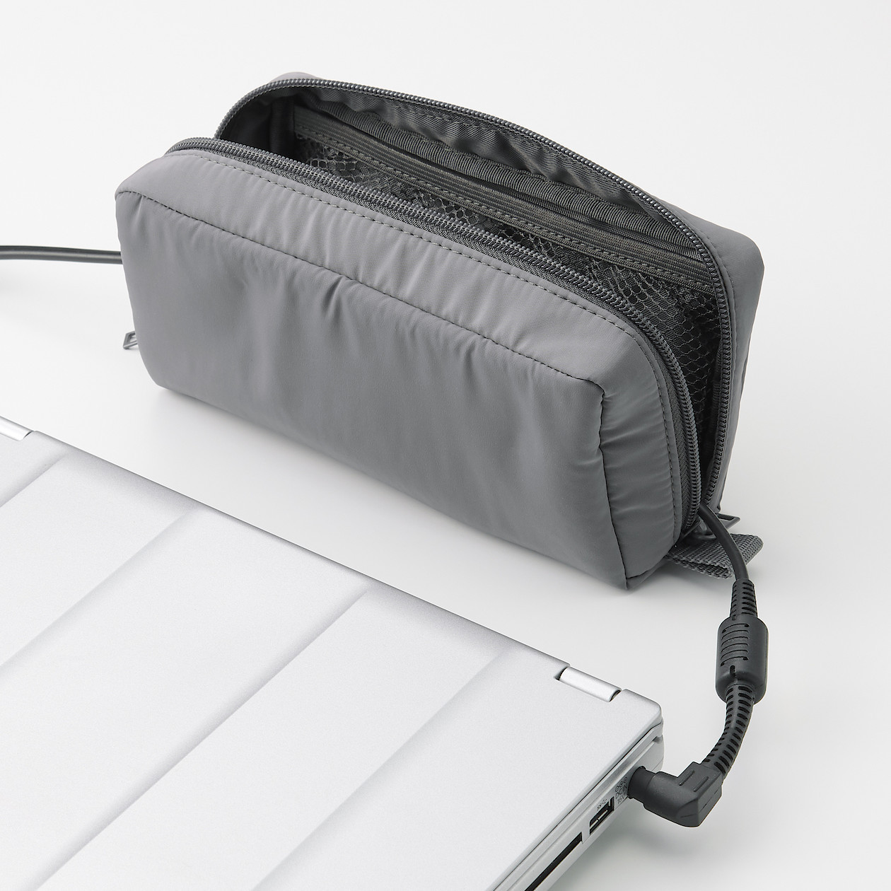 Szary organizer na kable i zasilacze